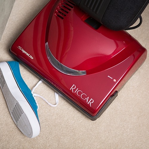 Blue shoe next to red vacuum